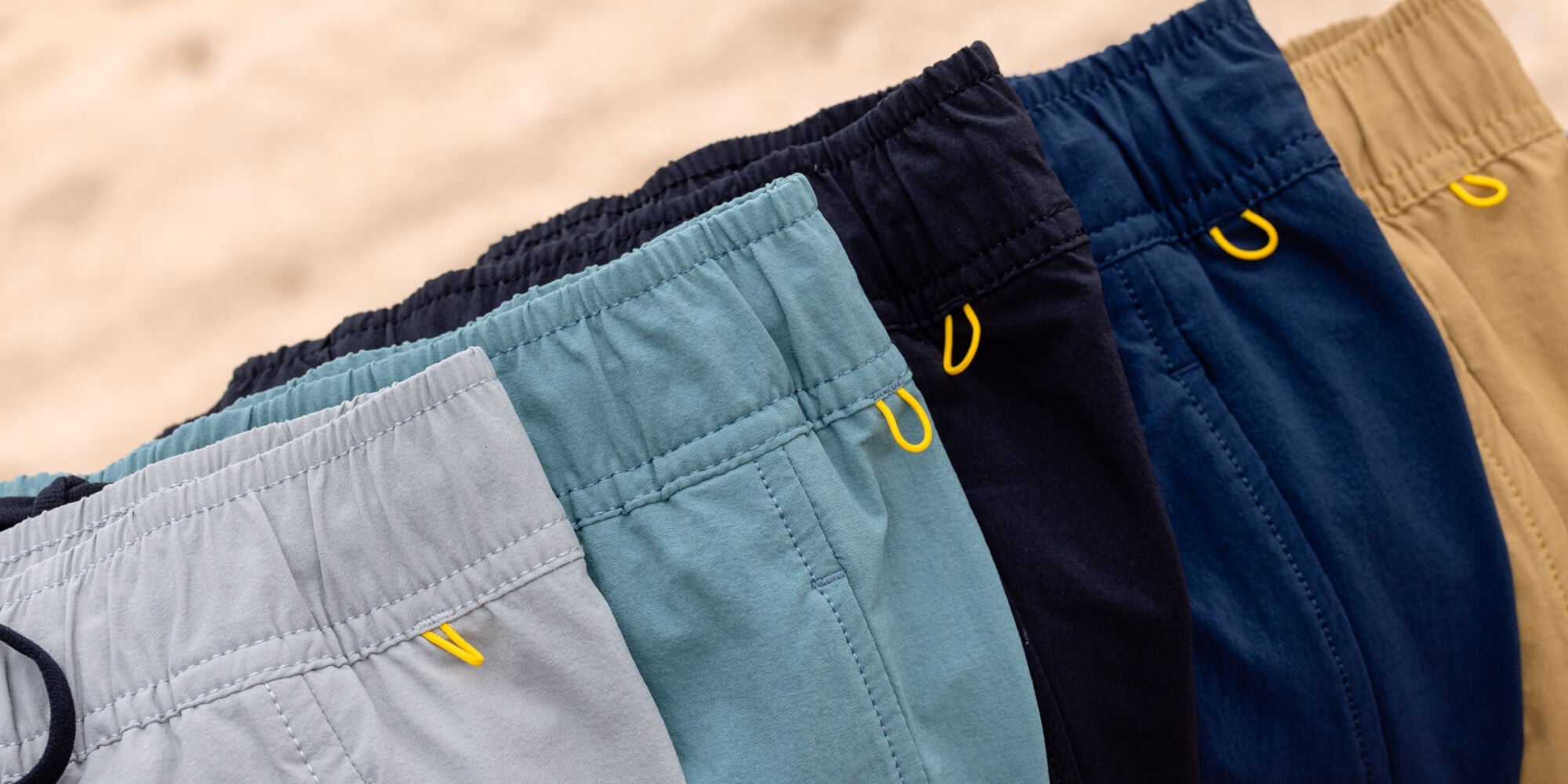 Five pairs for elastic waist shorts laying on a tree